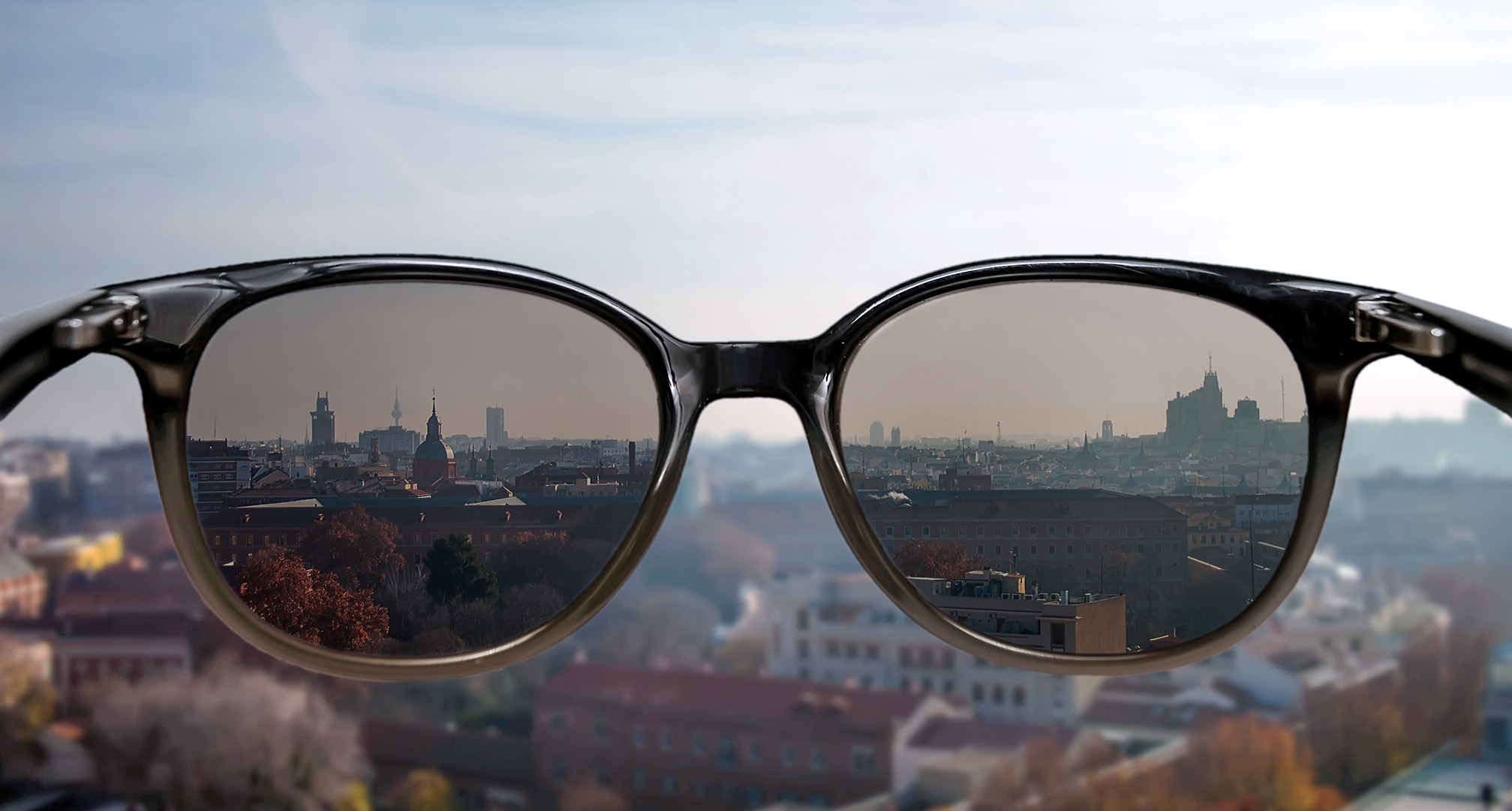 sunčane naočale držane ispred gradskog pejzaža u pozadini